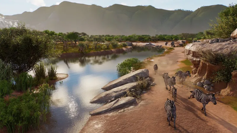 Planet Zoo 2 promotional zoo scene showing zebras beside a river habitat